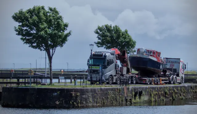A boat being lifted by crane on the quayside