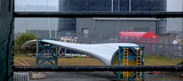 The white curve of a hull in the boatyard